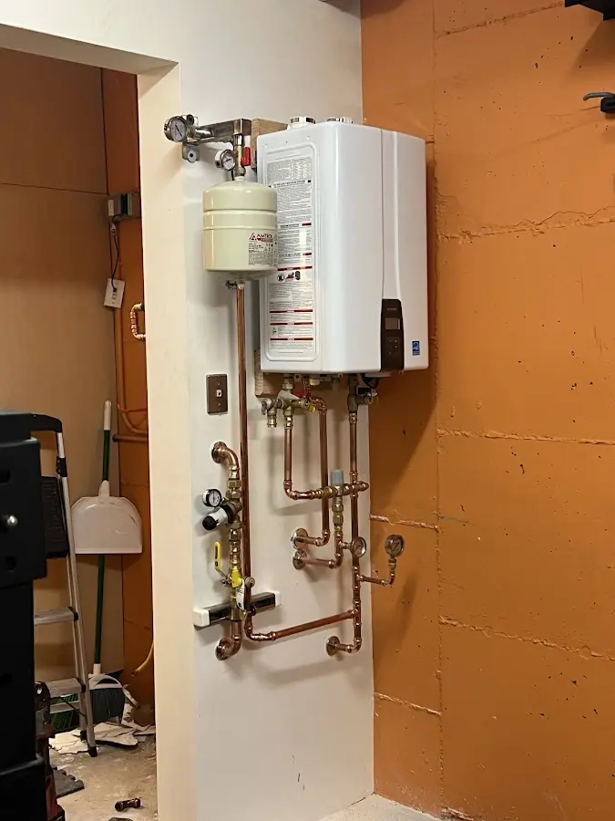 Plumbing technician inspecting water heater connections in Collegedale